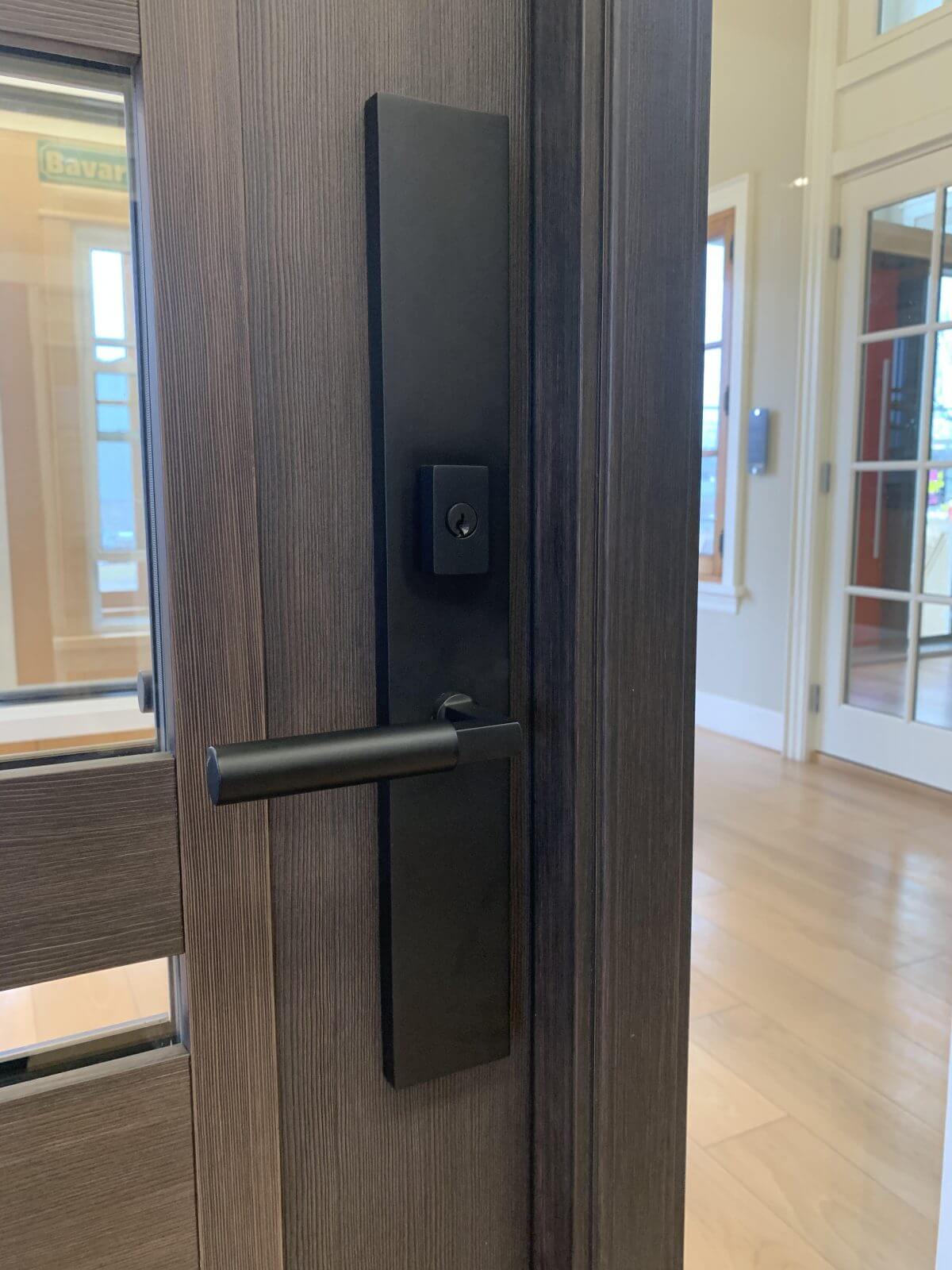 A photo of a one-piece plate in a flat back finish on a brown showroom door.