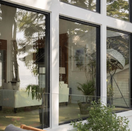 A close-up photo of a home with a white exterior and large, black-framed windows.