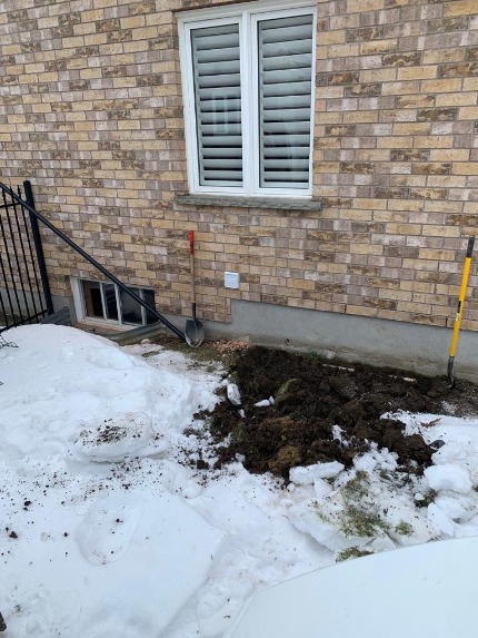 Excavating an area for an egress window installation.