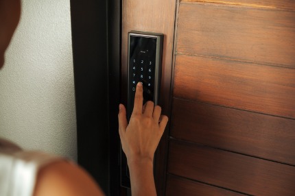 Someone using a lock pin pad on a door.