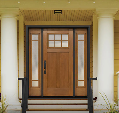 Craftsman-style wood front door with six-lite glass panel and frosted sidelights on yellow house